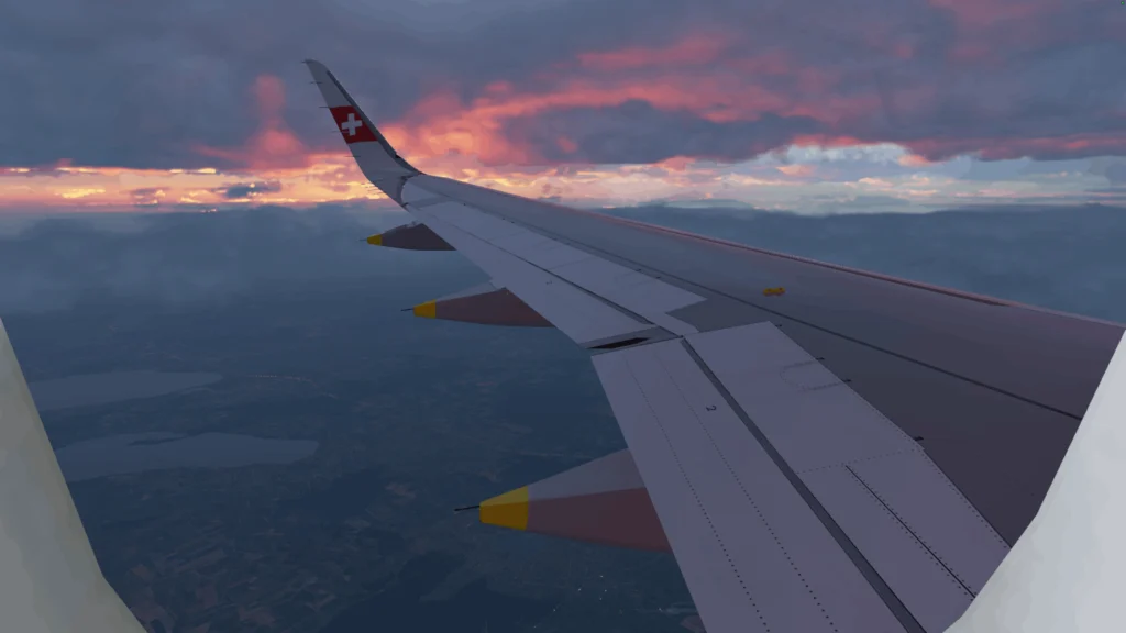 View of wing of plane from inside plane, at sunset