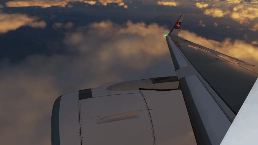 Wing and engine of plane seen from inside plane flying over clouds as dusk