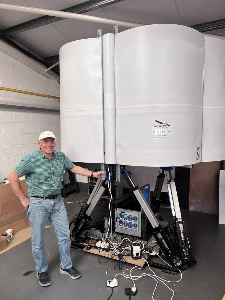 David Feetham standing beside his Cessna 172 motion flight simulator build